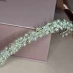 Close-up of pearl and clear crystal bridal headband detail on blush pink box