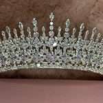 Close-up of a silver-tone bridal tiara with marquise and round-cut crystals in a tall, regal design.