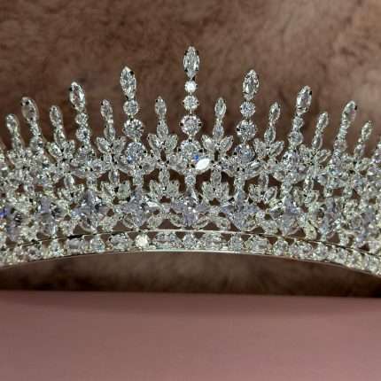 Close-up of a silver-tone bridal tiara with marquise and round-cut crystals in a tall, regal design.