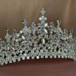 Close-up of the Crystal Cathedral Crown bridal tiara showing clear CZ marquise, pear, and round stones with intricate lace-like detailing.