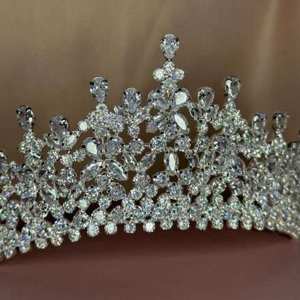 Close-up of the Crystal Cathedral Crown bridal tiara showing clear CZ marquise, pear, and round stones with intricate lace-like detailing.