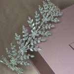 Angled full view of crystal leaf garland headband with cubic zirconia stones in silver tone