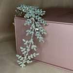 Silver botanical bridal headpiece featuring marquise CZ leaf clusters, styled on a pink box.