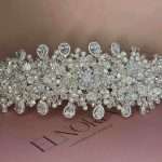 Close-up of Eternal Pearl Shine bridal headband featuring ivory pearls, clear crystals, Swarovski sparkle, and CZ pear-shaped teardrop drops on an Elnoria box.