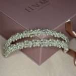Top view of a floral pearl and clear crystal bridal headband resting on a blush pink Elnoria box.