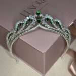 Silver bridal tiara headpiece with emerald green teardrop crystals and clear Swarovski & CZ stones in pear and round shapes, displayed on a gift box.