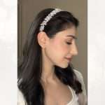 Woman wearing a pearl and clear crystal bridal headband in loose waves hairstyle