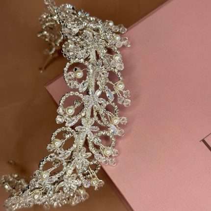 Side-angle view of the Opulent Pearl & Crystal Bridal Headband featuring Swarovski crystals, marquise and round CZ stones, pearl accents, and clear crystal beads on a pink Elnoria box.