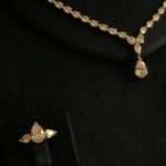 Pear-drop CZ ring and teardrop pendant necklace detail, rhodium-plated.