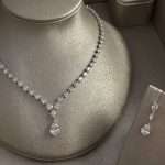 Tears of Joy Bridal Set close-up featuring a rhodium-plated cubic zirconia pear-drop necklace with teardrop pendant and matching drop earrings on a silver display.