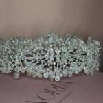 Close-up of a wide silver bridal headband with pearls, clear crystals, Swarovski accents, and cubic zirconia stones.