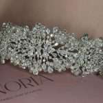 Angled close-up of a pearl and crystal bridal headband with Swarovski accents and cubic zirconia on an Elnoria box.