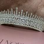 Sparkling silver-tone bridal tiara with marquise and round crystals, shown on a soft background.