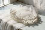 Pearl and crystal bridal headband resting on an ivory tulle veil