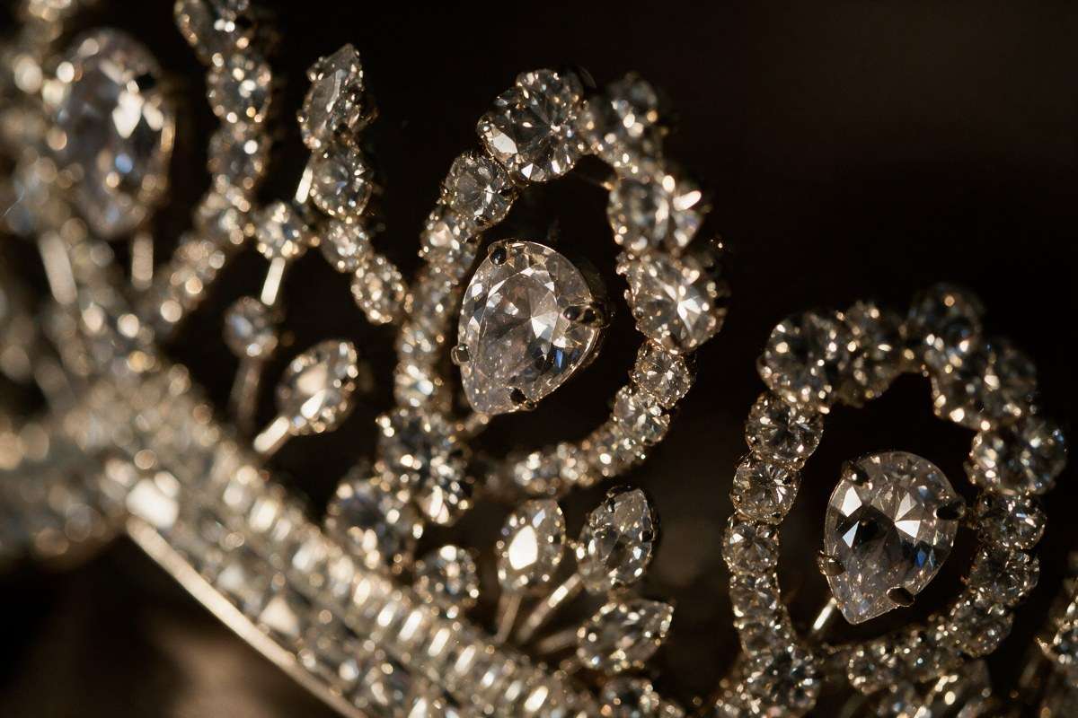 Macro close up of teardrop and marquise crystal stones on a silver bridal crown catching candlelight